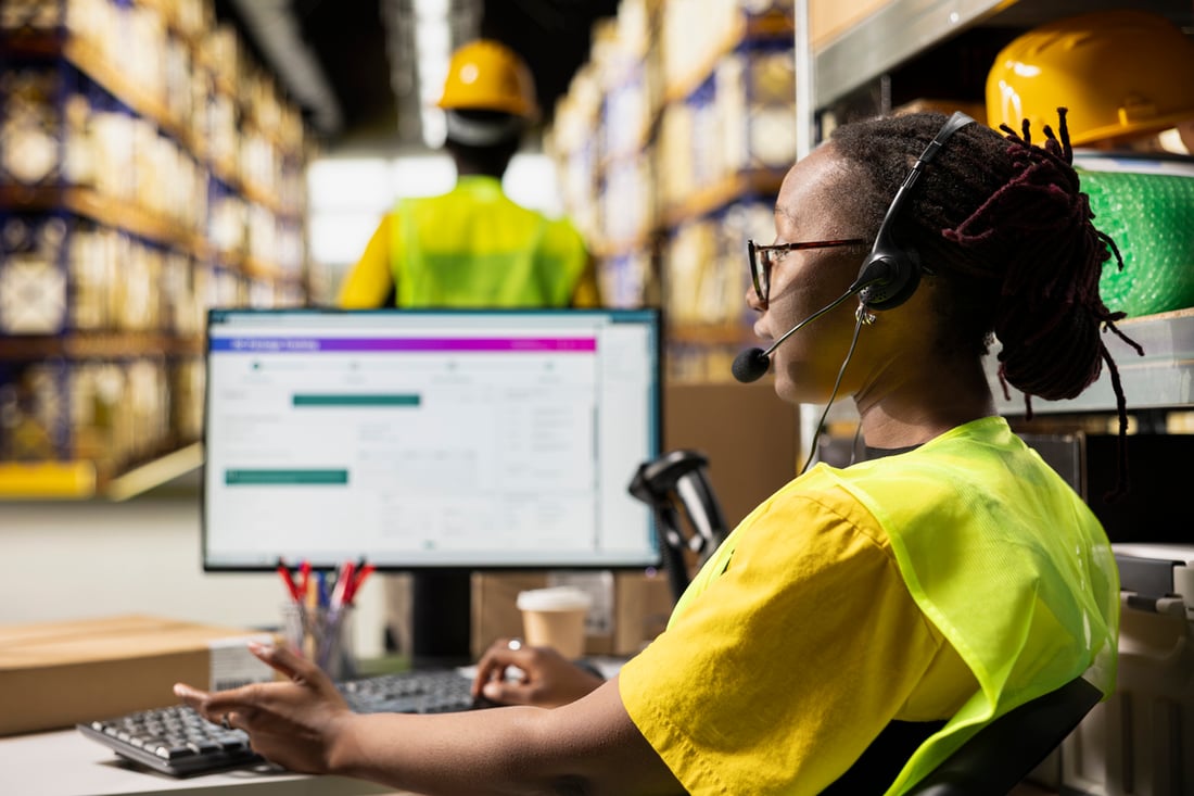 Small business owner using a mobile inventory tracking app in a warehouse.